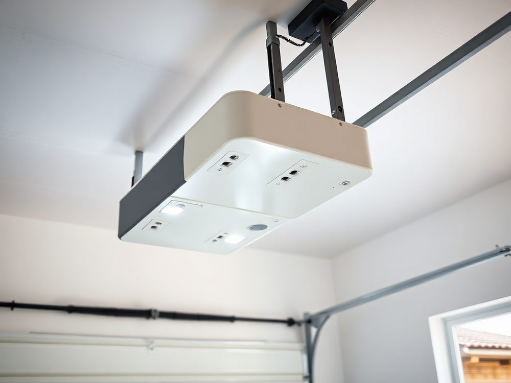 Newly installed garage door opener motor on a garage ceiling